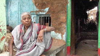 Neelamma, 80, keeps a watch on monkeys and strays in front of her damaged house in Kakkaragol of Koppal district. Pic: Savita Hiremath